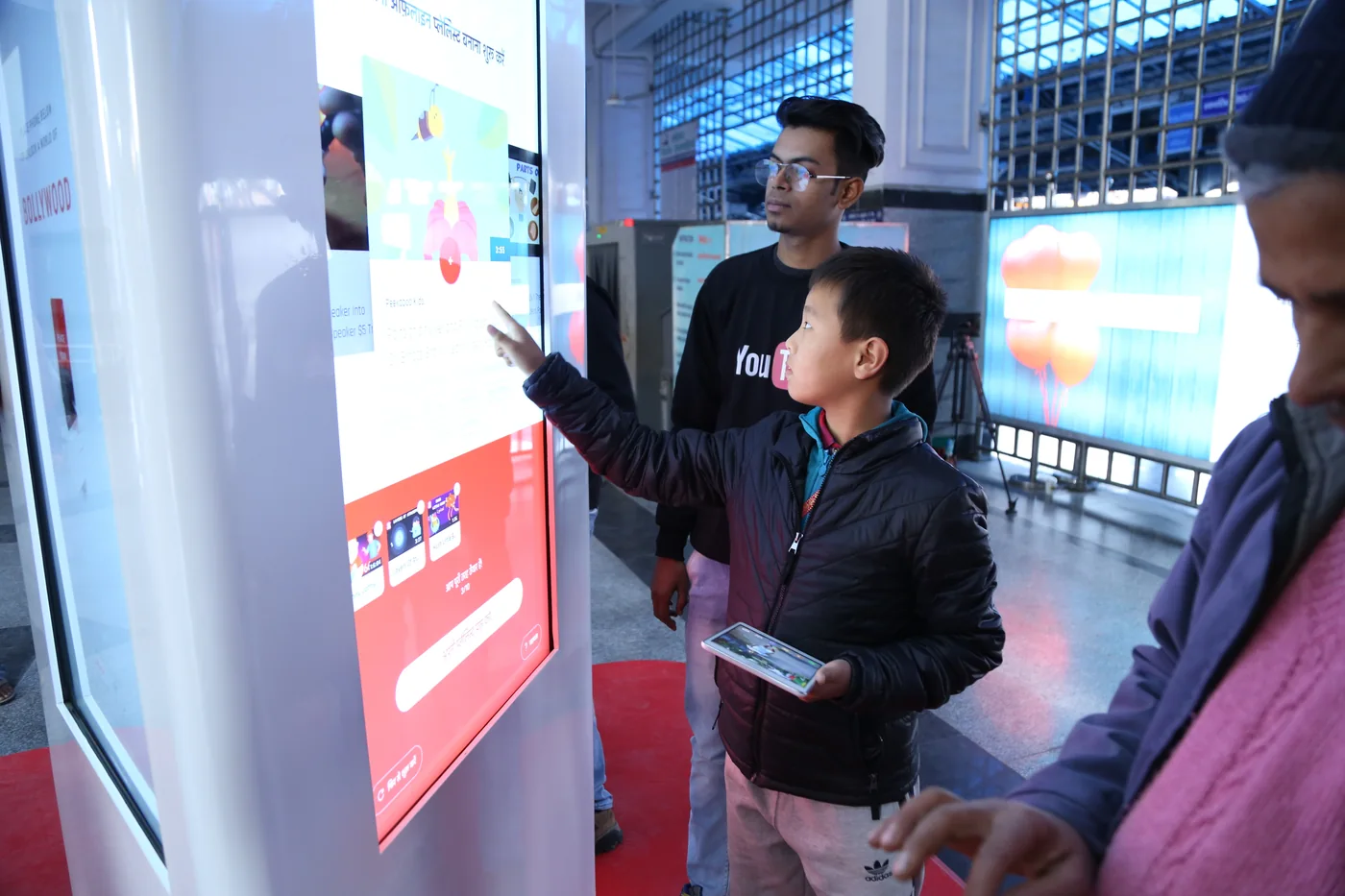 Commuters crowded around the lit kiosk screen at the station, building their offline playlists.